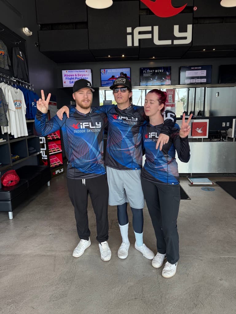 iFly indoor skydiving team throwing peace signs